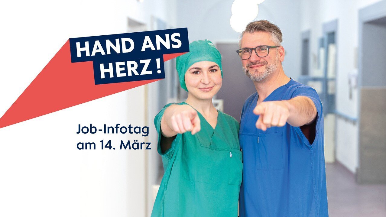 Zwei Personen in Arzt- und Pflegekleidung zeigen mit dem Finger auf den Betrachter. Neben ihnen steht der Text "HAND ANS HERZ!" und darunter "Job-Infotag am 14. März". Der Hintergrund ist ein heller Flur in einem Gesundheitswesen.